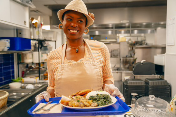 Nathalie Zola Malu, founder of Malkia & Co. Gourmets, holding a freshly prepared plate